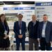 Four professionals at an Estel exhibition booth.